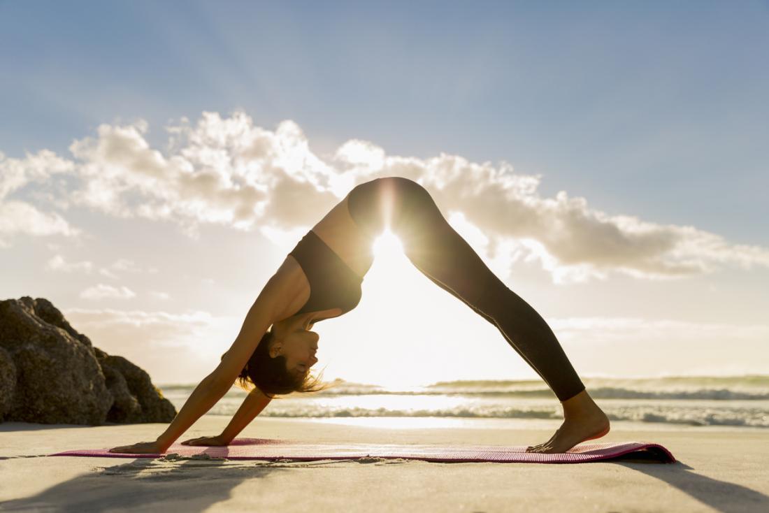 a-woman-practicing-yoga-on-the-beach.jpg